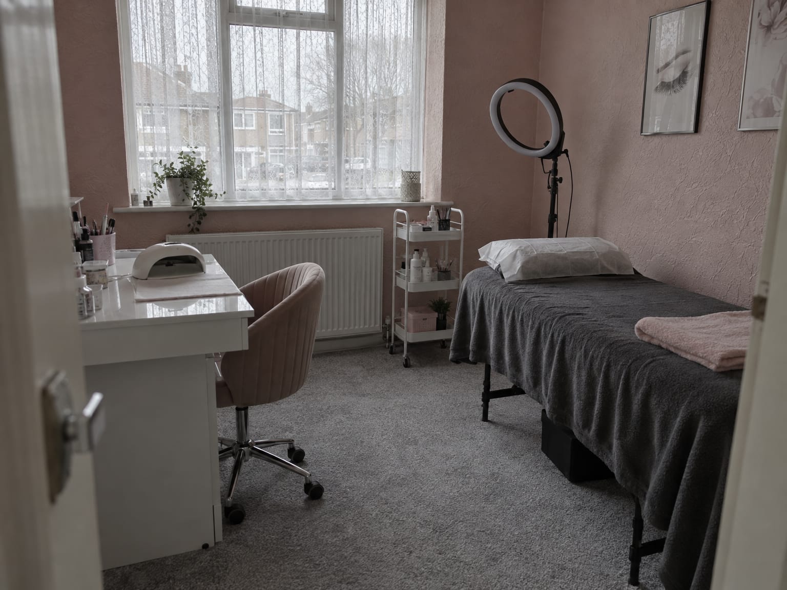 An empty home nail and lash studio in a spare bedroom, a lash bed and a nail desk by the window