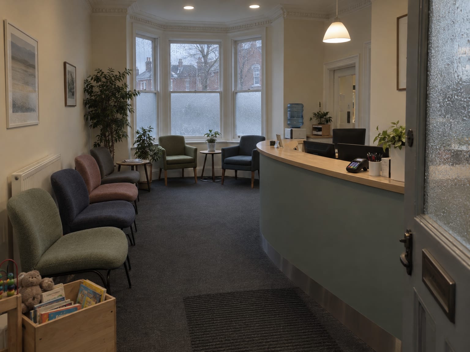 An empty dental reception early in the morning, waiting chairs and a card machine on the desk